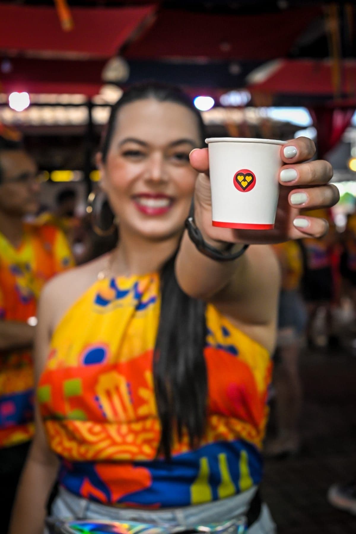 Convidada recebendo café 3 Corações em copo personalizado