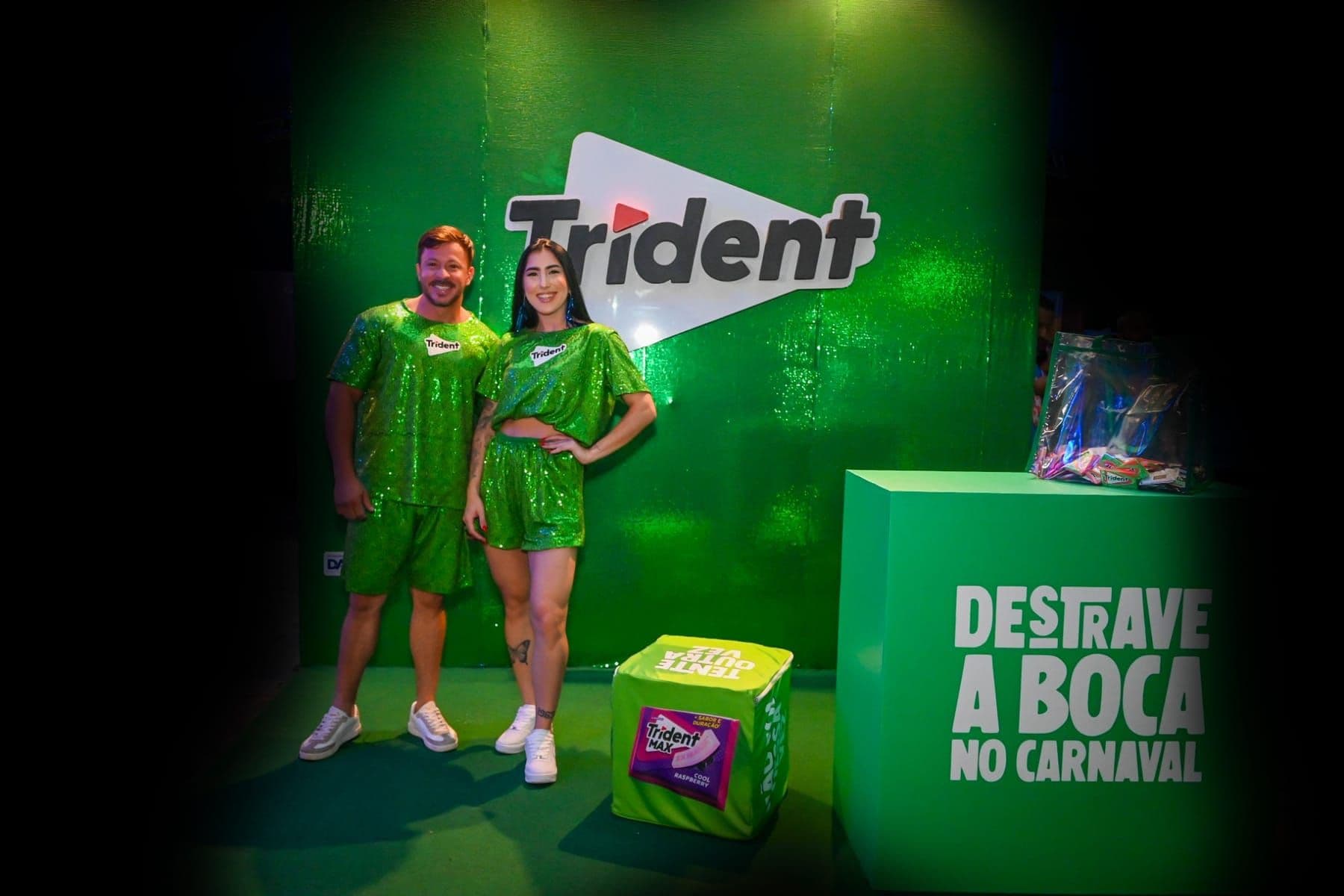 Cenografia verde da ativação Trident no Carnaval, com dupla de anfitriões